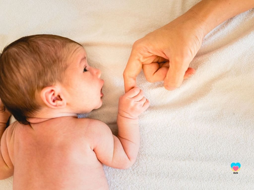 baby touching adults finger grasping