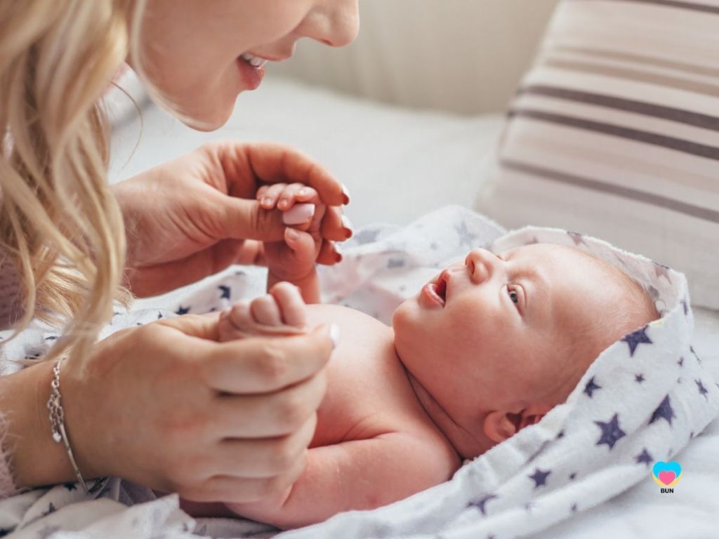 mother talking to newborn baby engaging
