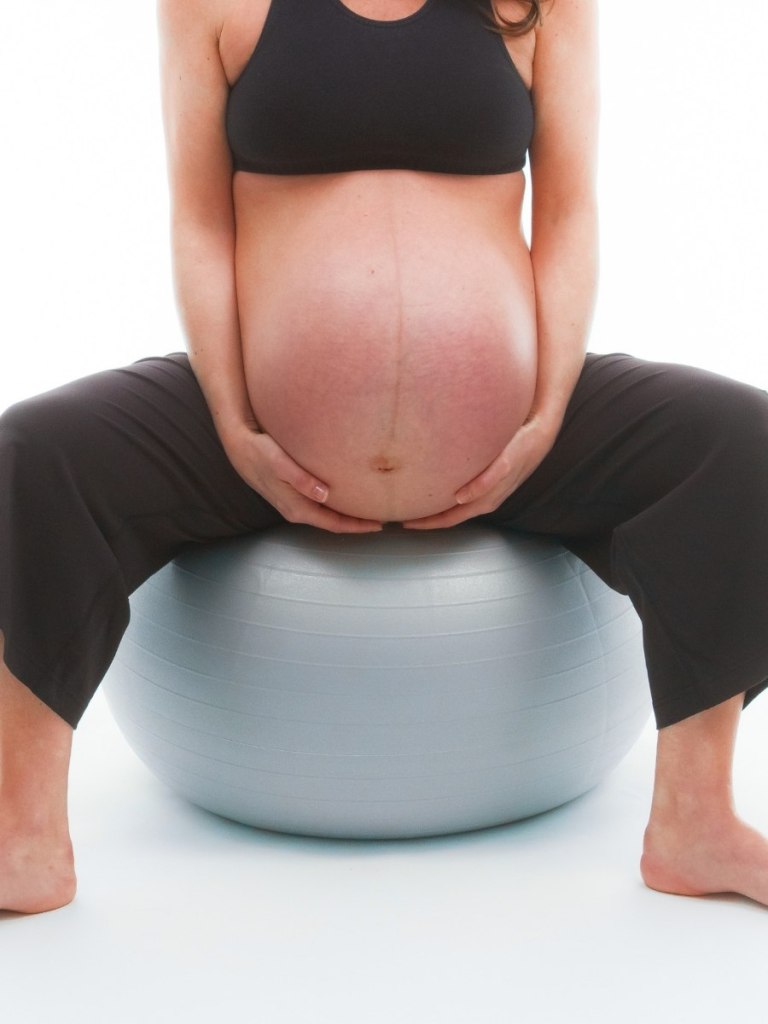 very pregnant women sitting on bosa ball birth ball